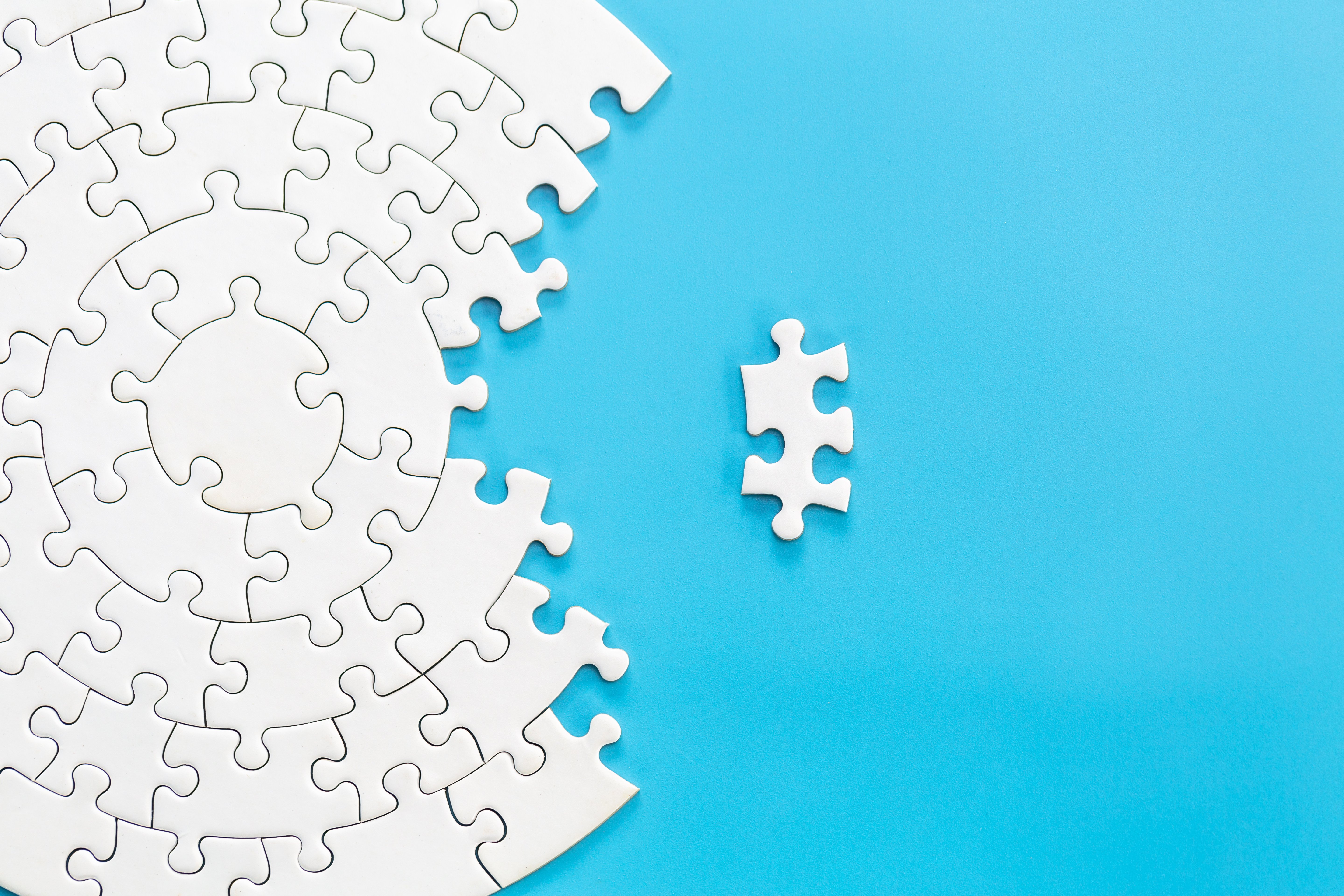 blue background of a circle puzzle with a section incomplete and one puzzle piece standing alone