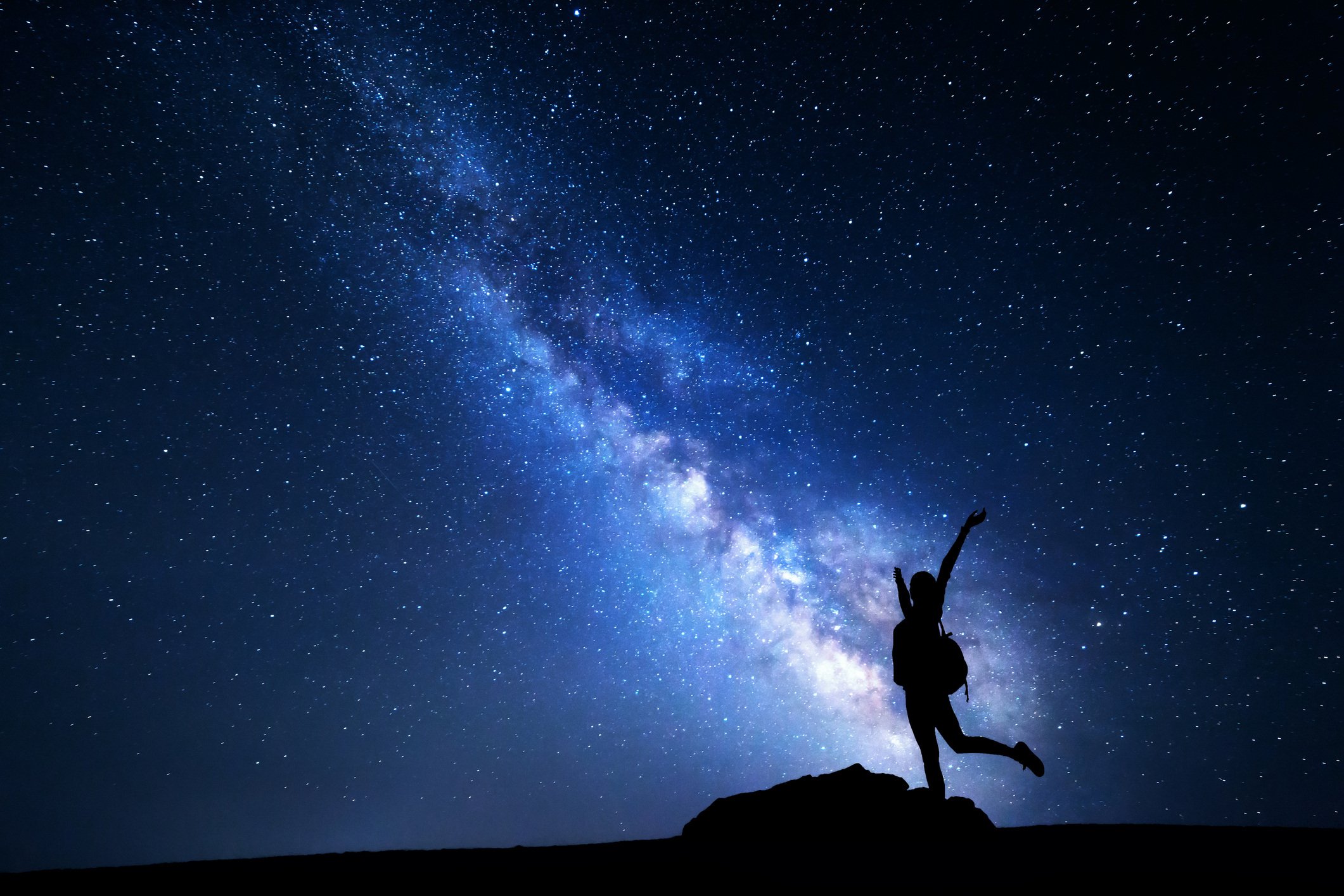 person in the nightime sky reaching for the stars