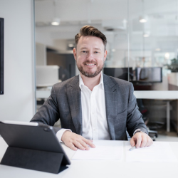Chris sitting behind a desk smiling
